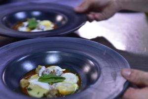 a person holding a bowl of food on a table at Antica Stazione in Chiaramonte Gulfi