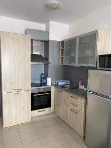 a kitchen with wooden cabinets and stainless steel appliances at Luxory Apartament on the Seaside, Gradina beach, St Nicholas Complex in Chernomorets