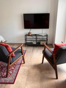 a living room with two chairs and a flat screen tv at b im Welschen in Oerlinghausen