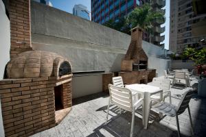 サンパウロにあるApartamento Triplex Place Vendomeのパティオ(レンガ造りのオーブン、テーブル、椅子付)