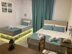a room with two beds and a table and a table sidx sidx sidx at Armeno Studios in Limenaria