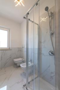 a bathroom with a glass shower and a toilet at Borgo degli Ulivi Residence di Olympic Garda Lake in Toscolano Maderno