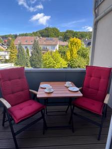 d'une table et de deux chaises sur un balcon avec vue. dans l'établissement b im Welschen, à Oerlinghausen