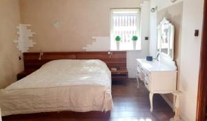 sypialnia z łóżkiem, komodą i lustrem w obiekcie Dom na Leszczynowej Górce - plaża, las w mieście Ełk