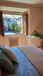 een slaapkamer met een groot bed en een raam bij Dúplex en Pazo Marqués de Aranda in Pontevedra