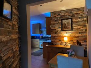 cocina con pared de piedra y mesa con sillas en Masons Nook 292 Mansfield Road NG174HR en Skegby