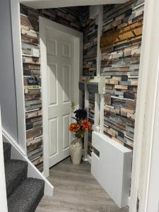 a hallway with a wall of reclaimed wood at Masons Nook 292 Mansfield Road NG174HR in Skegby