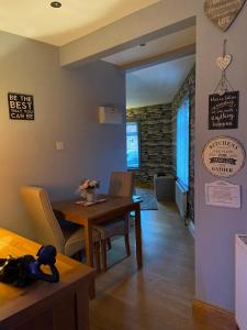 a dining room with a table and chairs and a room with a brick wall at Masons Nook 292 Mansfield Road NG174HR in Skegby