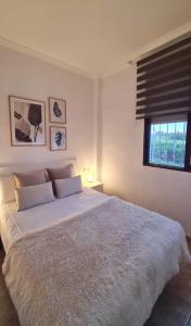 1 dormitorio con 1 cama blanca grande y ventana en La Voreta, en Villajoyosa
