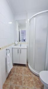 baño blanco con ducha y lavamanos en La Voreta, en Villajoyosa