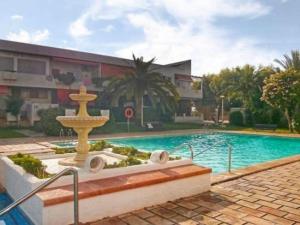 a swimming pool with a fountain in front of a building at La Voreta in Villajoyosa