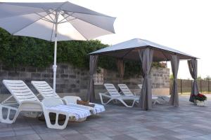 grupa krzeseł i parasoli na patio w obiekcie Apartmani Residence Jana w mieście Vabriga