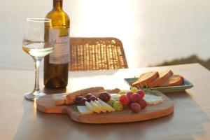 a bottle of wine and a plate of cheese and bread at SECRET HILL in Athani