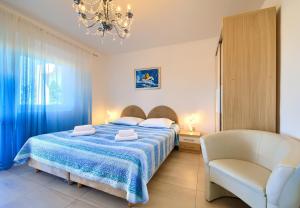 a bedroom with a bed and a chair and a chandelier at Villa Sunce in Punat