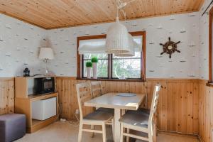 uma sala de jantar com uma mesa de madeira e cadeiras em Guesthouse on an Island em Dekarsön