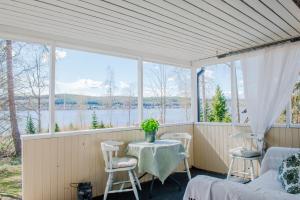 a screened in porch with a table and chairs at Guesthouse on an Island in Dekarsön