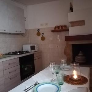 una cocina con una mesa con copas de vino y una vela en Casa Mafalda, en Aradeo