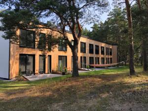a building with a tree in front of it at 11 Pine View in Ķesterciems