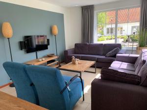 sala de estar con 2 sofás y TV en Haus Willy Bad Bentheim, en Bad Bentheim