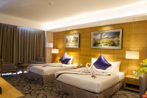 ein Hotelzimmer mit 2 Betten und einem Tisch in der Unterkunft Iris Hotel Can Tho in Cần Thơ