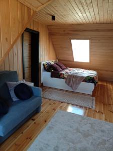 Zimmer mit 2 Betten, einem Sofa und einem Fenster in der Unterkunft Agroturystka Podlasie Dom całoroczny nad stawem in Dobrzyniewo Duże