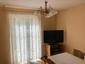 sala de estar con TV y ventana en DOM OSTRÓDA-CISZA I SPOKÓJ, en Ostróda