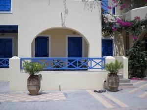 two large vases with plants in them in front of a building at Santorious Family Apartment in Megalochori