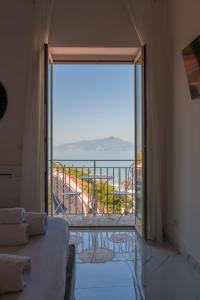 Zimmer mit einer großen Glastür, die auf einen Balkon führt. in der Unterkunft Naro Suites and Rooms in Bacoli