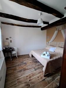 een slaapkamer met een bed en een houten vloer bij Il Gelsomino Apartment in Pitigliano