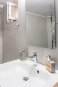 a white bathroom with a sink and a mirror at Neoria apartment in Chania Town