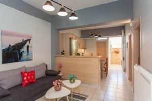 a living room with a couch and a kitchen at Neoria apartment in Chania