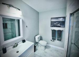 a white bathroom with a toilet and a sink at Secret Serenity! Roomy! Pool! 5 min from Beach! in Deerfield Beach +13 photos