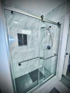 a shower with a glass door in a bathroom at Secret Serenity! Roomy! Pool! 5 min from Beach! in Deerfield Beach