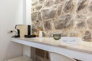 a counter with a coffee maker and a glass on it at In centro da Viola - Eco Design Rooms in Olbia +46 photos