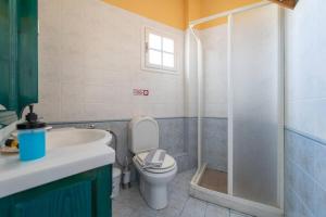 a bathroom with a toilet and a sink and a shower at Santorious Flower Covered Apartment in Megalochori