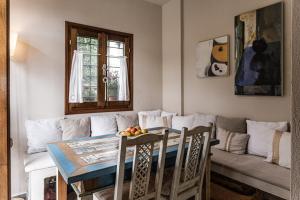 sala de estar con mesa y sofá en ILOI’s Villa in peaceful Village w. Private Beach, en Koropi