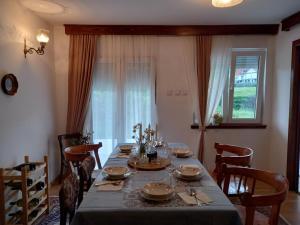 a dining room with a long table and chairs at Konak Ugnji-Village in Cetinje