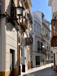 un callejón con edificios y un letrero de calle en un edificio en FAM Sevillian Townhouse, en Sevilla