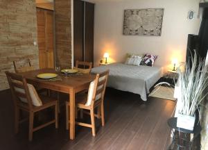 een slaapkamer met een bed en een tafel en stoelen bij Studio Bijou Plage Antibes Juan-les-Pins in Antibes