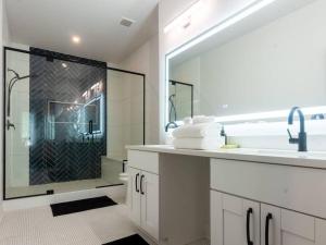 a white bathroom with a shower and a sink at Five75Lux ATL King Bed & Game Room Downtown in Atlanta