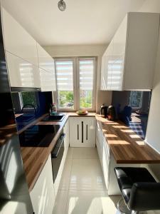 cocina con armarios blancos y ventana grande en Apartament Glamour Work&Relax, obok ARENY Gliwice, FV en Gliwice