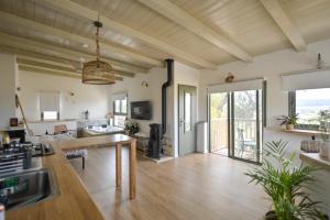a kitchen and living room with wooden ceilings and a table at צימר חלון לרקפות zimer Window for primroses עם ג'קוזי לנוף in Tal Shaẖar