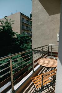un tavolo in legno e una sedia sul balcone di EVRIDIKI suite AXD a Alexandroupoli