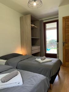 2 camas en un dormitorio con ventana en Appartement rez de jardin, 2 chambres/ 4 personnes, garage., en Briançon