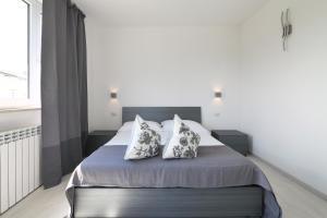 a bedroom with a bed with two pillows on it at Borgo degli Ulivi Residence in Toscolano Maderno