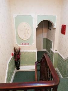 a staircase in a building with a vase of flowers at The Hebburn Great House in Hebburn-on-Tyne