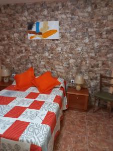 a bedroom with a bed and a brick wall at Casa Blanca in Alojera