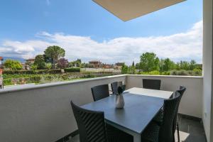 a table and chairs on a balcony with a view at Borgo degli Ulivi Residence in Toscolano Maderno