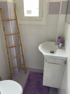 a bathroom with a sink and a toilet and a ladder at Casa arcobaleno in Ventimiglia