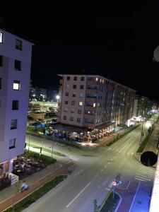 an empty city street at night with a building at Apartman Manja in Lukavica